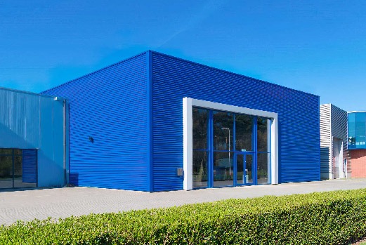 Commercial unit clad in bright blue profiled metal sheeting with a glazed entrance bay