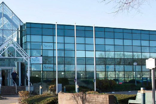 Three-storey office block with a green tinted glazed curtain wall elevation and aluminium framing