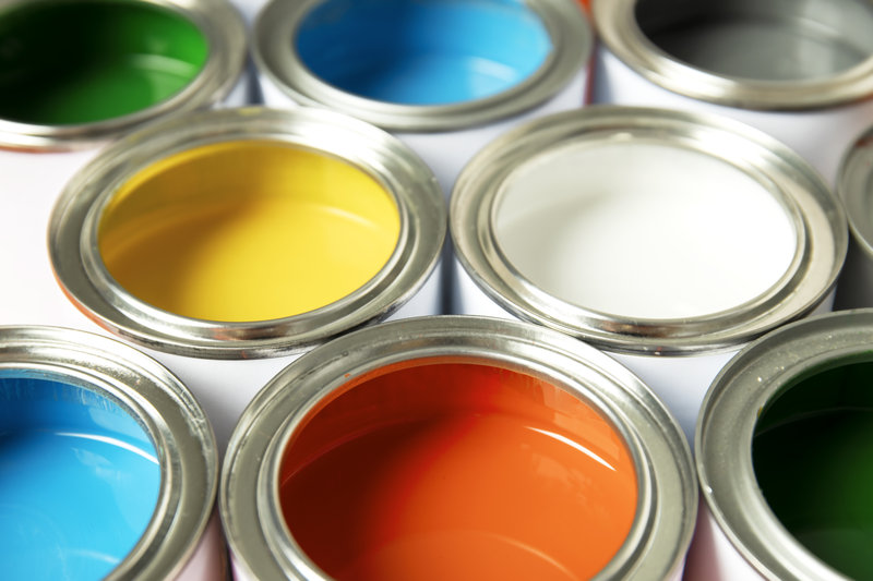 a photograph of paint tus with their lids open to reveal several different colours to choose from